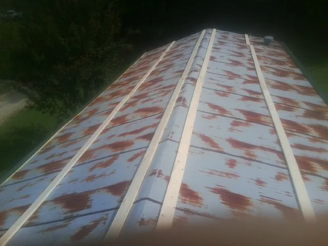 Rusted metal roof panels with new wood purlins before replacement — Storm Damage Roof Repair in Swiftwater by Roofing Brothers